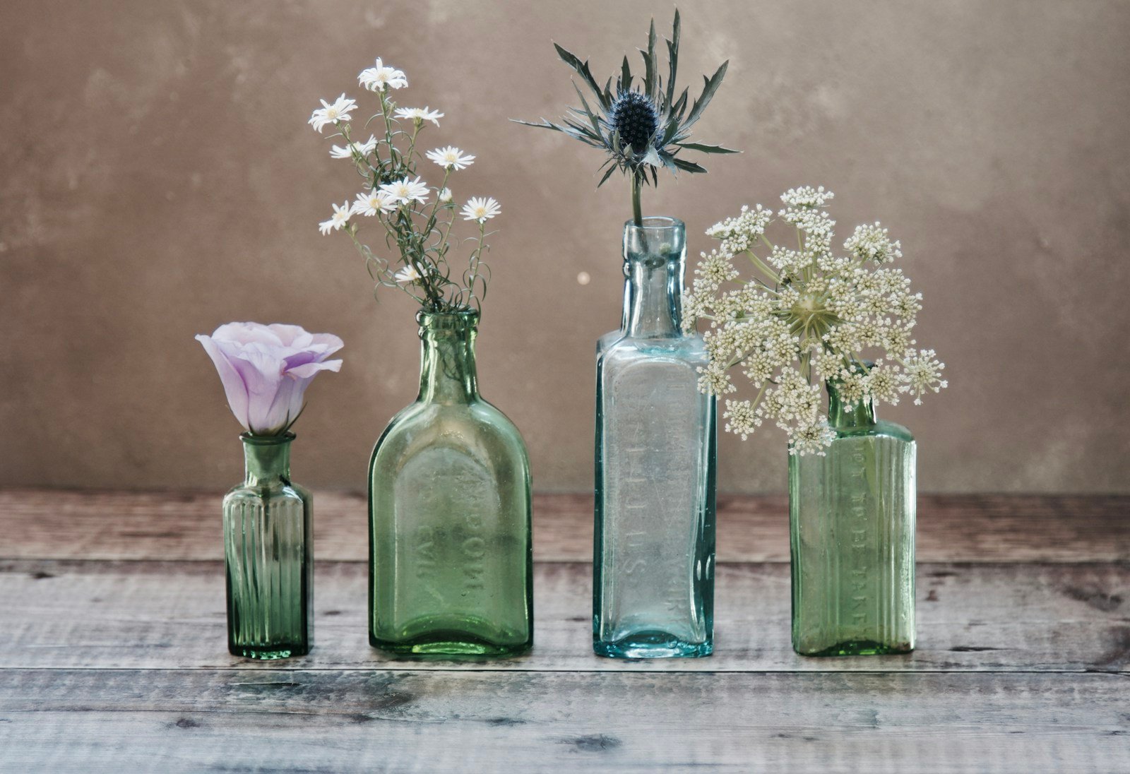 Fleurs disposées dans une bouteille en verre recyclée